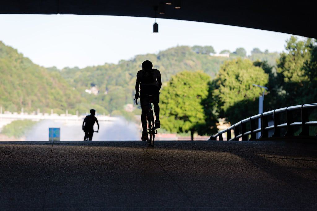 A picture of two people riding bicycles but you can only see their silhouette