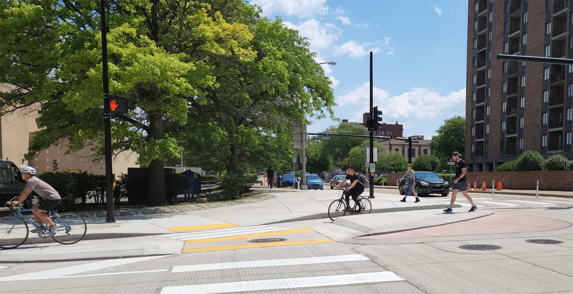 Image of people riding bikes and walking across the intersection of Federal St and Allegheny Circle