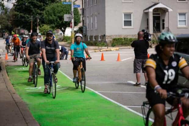 Picture of people biking along a green bike lane.