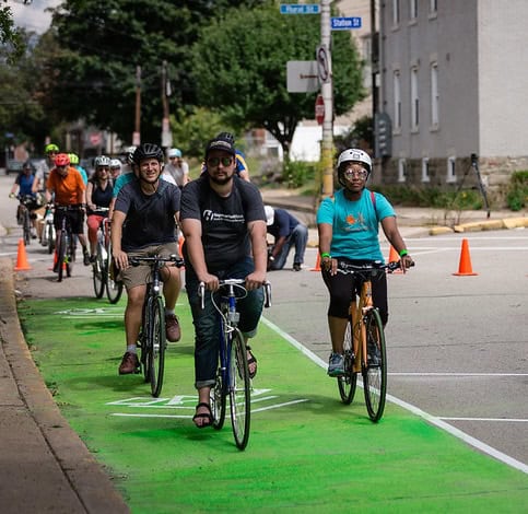 Picture of people riding bikes in a temporary green bike lane.