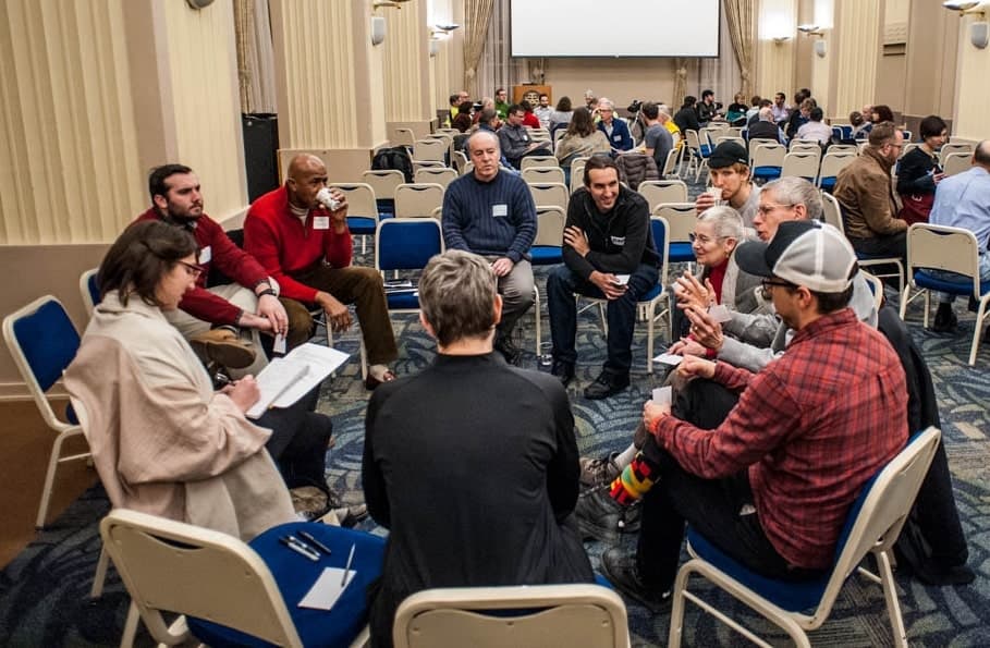 People gathered in a circle talking.