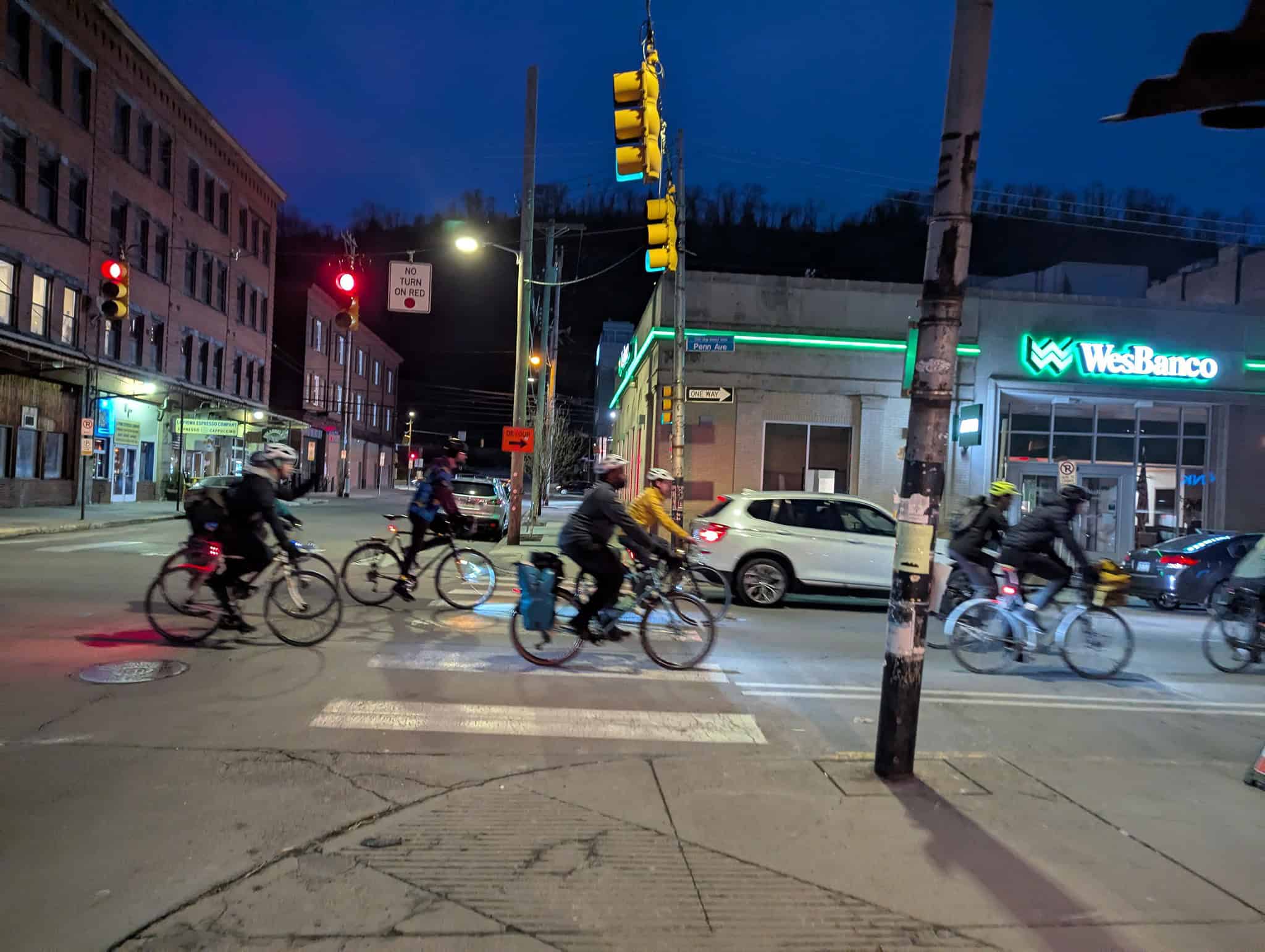 Cyclists in motion along Penn Ave with WesBanco in the background.