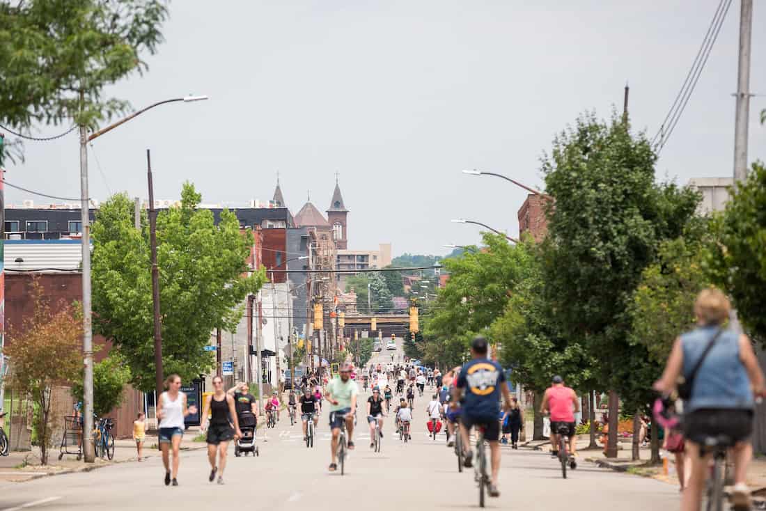People walk, bike, and roll on a car-free street between PGH's Lawrenceville and Strip District.