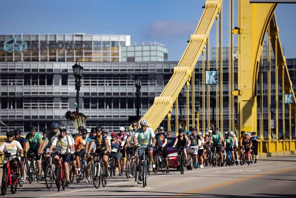 A large group of cyclists on the Andy Warhol bridge