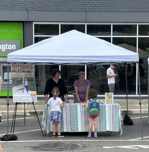 Volunteers educate youth and families about safe walking at a table at OpenStreetsPGH.