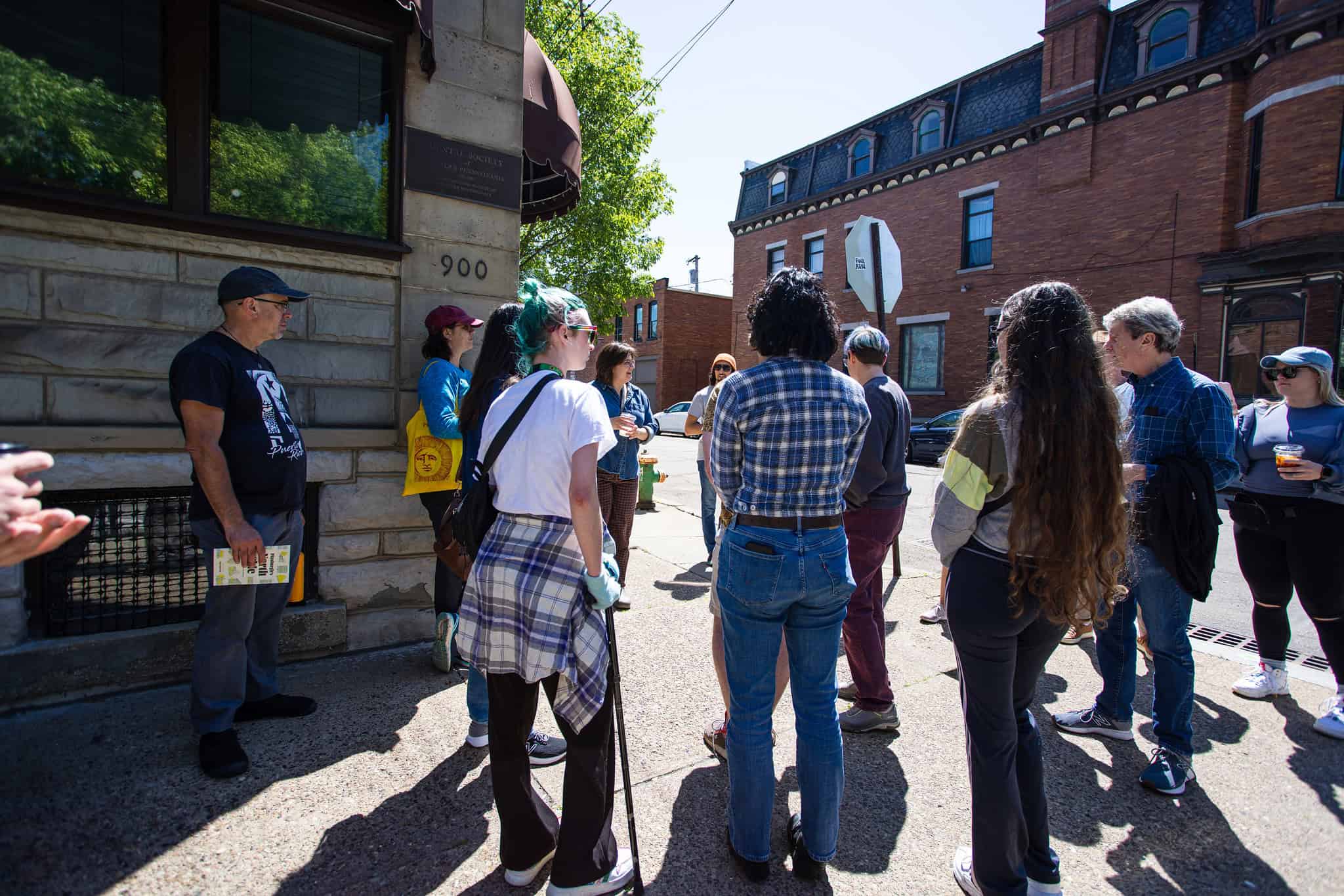 image of people standing on a sidewalk in the Northside of Pittsburgh about to go on a walk