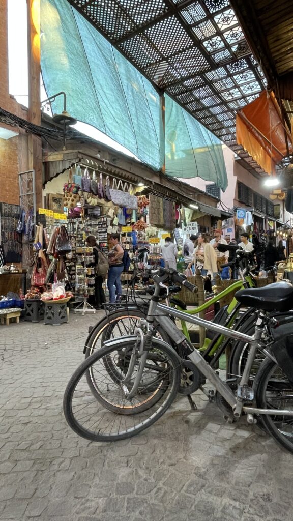 Bikes in the foreground of busy marketplace shops