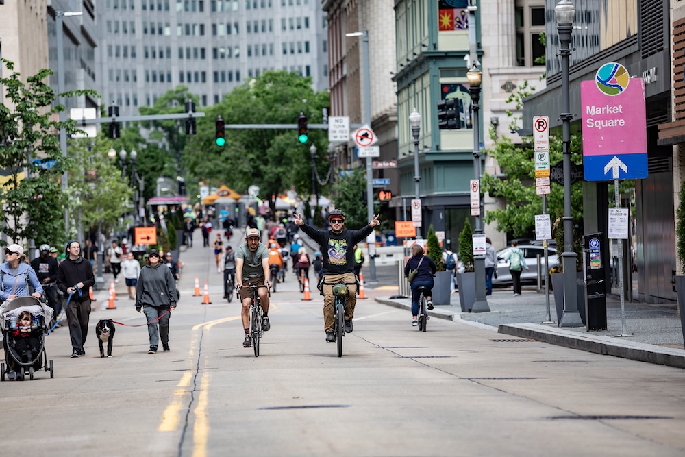 a group of people riding bikes having fun on Forbes Ave in Downtown Pittsburgh