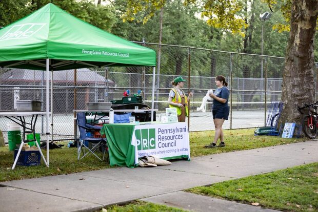 A green PA Resources Council tent at PedalPGH with two people talking