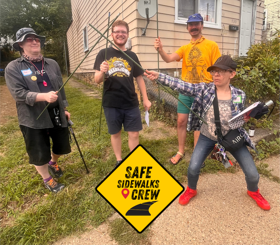 A picture of volunteers holding up tomato stakes like the three musketeers.